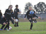 Dicey Delano, left, and Ava Bond practice with third- and fourth-grade Washington Timbers Football Club players Wednesday evening at Harmony Sports Park in the east Vancouver area.