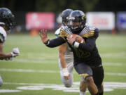 Hudson's Bay's Akilotoa Kaumatule (15) escapes Woodland players during the second quarter against Woodland at Kiggins Bowl in Vancouver, Friday Sept. 22, 2017.