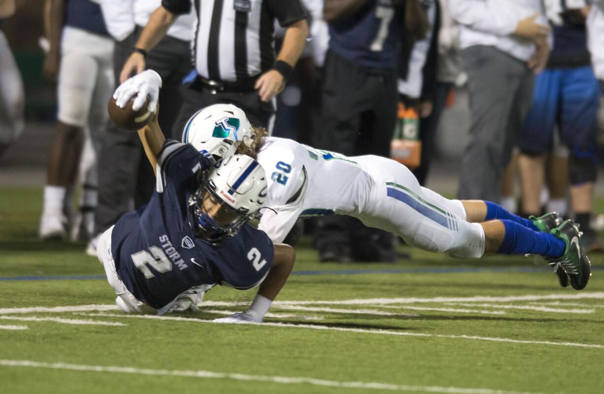 Storm's Jovon Sewell (2) comes down with the ball from a tackle by Thunder's Payton Regas (20) during Friday night's football game on Sept. 22, 2017.