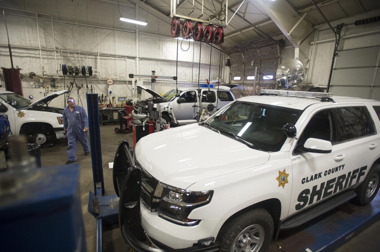 Craig Callaway, a county technician, walks past sheriff’s office vehicles parked at Clark County Fleet Services.