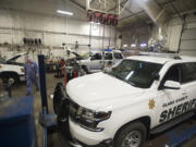 Craig Callaway, a county technician, walks past sheriff’s office vehicles parked at Clark County Fleet Services.