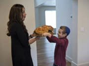 Tzivie Greenberg and her son, Efraim, 8, carry round loaves of challah to the dinner table in preparation for evening celebrations of the first night of Rosh Hashanah, the Jewish New Year, at their home in Vancouver on Wednesday afternoon. While challah is often served throughout the year in braided form, the round shape at the new year represents the cyclical nature of time, and the cinnamon and sugar represent a sweet new year. Tzivie and her husband, Rabbi Shmulik Greenberg, are co-directors of the Chabad Jewish Center in northeast Vancouver.