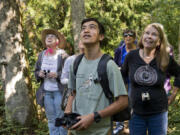 Tyler Hartlauer, 14, a volunteer, listens to a song bird’s call to find its location. Dorrie Estriblu of Vancouver, at right, listens along with Glenda McCune, at left in hat, also of Vancouver.