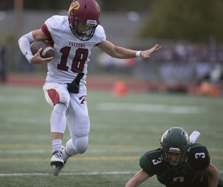 Prairie's Jayson Maddux (18) leaps past Evergreen's Nadil Hodzic (3) on his way to score in the fourth quarter at McKenzie Stadium on Friday afternoon, Sept. 29, 2017.