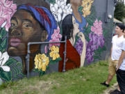 Garrett Holiday, left, and Isaiah Romero check out one of four recently finished murals painted on the walls of buildings along East Fourth Plain Boulevard. The murals were created as part of the Fourth Plain Forward effort.