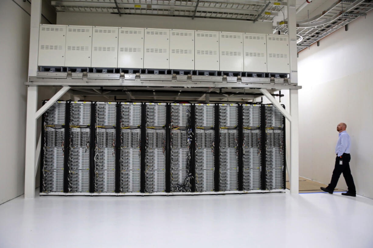 Microsoft engineer Sean James is dwarfed by the superstructure frame that supports servers on the bottom and European-made fuel cells on top at a building in Sodo. The company hopes to begin testing soon using natural-gas-powered fuel cells to power data centers.