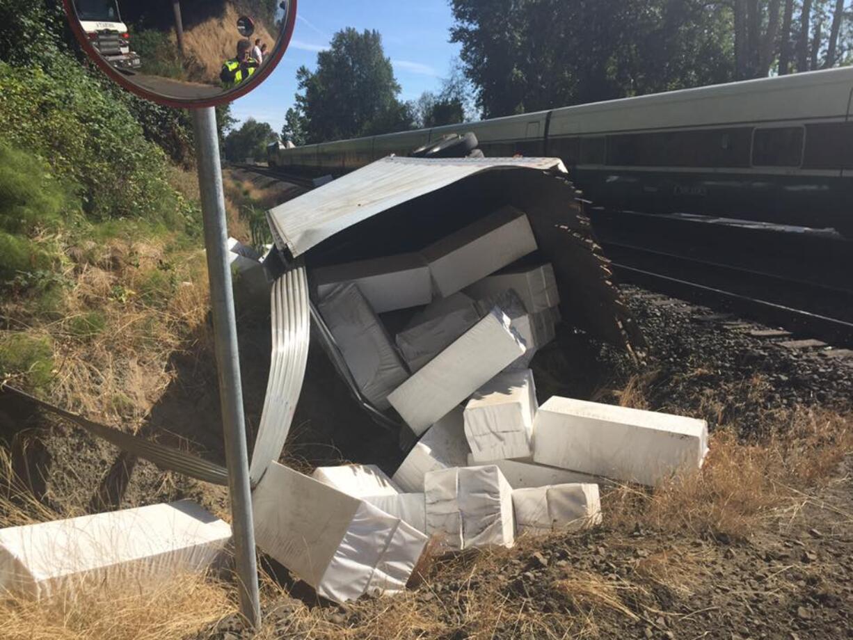 A mangled trailer full of foam blocks bound for the Felida docks sits beside the railroad crossing at Northwest 122nd Avenue after it was caught on the crossing and hit by an oncoming train. No one was hurt.