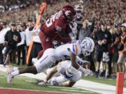 Washington State running back Jamal Morrow (25) dives for the game winning touchdown over Boise State cornerback Reid Harrison-Ducros, center, and linebacker Tyson Maeva during third overtime at Pullman, on Saturday, Sept. 9, 2017. Washington State won 47-44.