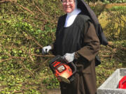 In this Tuesday, Sept. 12, 2017, photo provided by the Miami-Dade Police Department, Sister Margaret Ann holds a chain saw near Miami, Fla. Police said the nun was cutting trees to clear the roadways around Archbishop Coleman Carrol High School in the aftermath of Hurricane Irma.