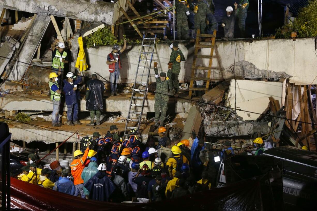 Rescue personnel work on the rescue of a trapped child at the collapsed Enrique Rebsamen primary schoool in Mexico City, Sept. 20, 2017.  A wing of the school collapsed after a powerful earthquake jolted central Mexico on Tuesday, killing scores of children and trapping others.