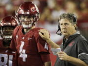 Washington State coach Mike Leach, right, speaks with quarterback Luke Falk during the first half of an NCAA college football game against Boise State in Pullman, Wash., Saturday, Sept. 9, 2017.