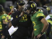 Oregon head coach Willie Taggart, left, talks to backup quarterback Taylor Allie after starting quarterback Justin Herbert left the field with an apparent injury during the first quarter against California in an NCAA college football game Saturday, Sept. 30, 2017, in Eugene, Ore.