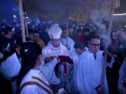 Chinese bishop Joseph Li Shan, center, arrives Dec. 24, 2015, for a Christmas Eve mass at the Southern Cathedral, an officially sanctioned Catholic church in Beijing. The Vatican’s efforts to heal a decades-long rift with China appear to have stalled, with each side still unwilling to accept controversial bishops appointed by the other. In recent months, Beijing has appeared to take a harder line toward believers, and has ordered the country’s estimated 12 million Catholics to shun foreign influence and to “Sinosize” their Church.