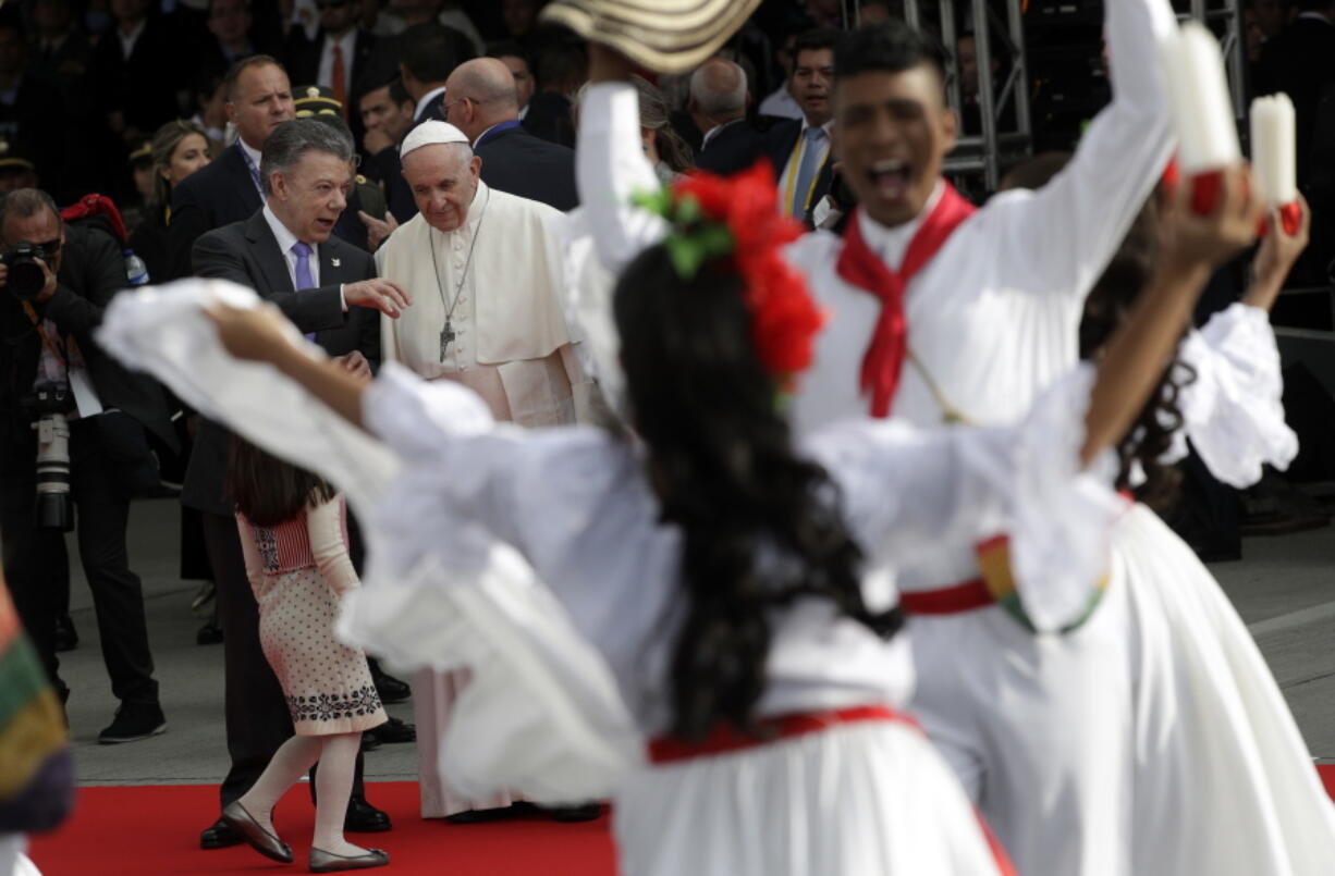 Colombia’s President Juan Manuel Santos talks to Pope Francis during the pontiff’s welcoming ceremony at El Dorado airport in Bogota, Colombia, on Wednesday. Pope Francis has arrived in Colombia for a five-day visit.