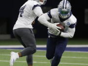 Dallas Cowboys quarterback Dak Prescott (4) hands off to teammate running back Ezekiel Elliott (21) during practice Thursday at Frisco, Texas.