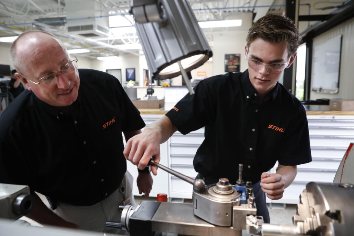 Apprentice Ryan Buzzy, right, works May 25 with Skip Johnson, a trainer for the Stihl Inc. apprenticeship program, on a metalworking lathe in their training area at the Stihl Inc. manufacturing facility in Virginia Beach, Va. U.S. factories expanded at a brisk pace in August. The Institute for Supply Management’s manufacturing index is at its highest point since April 2011.