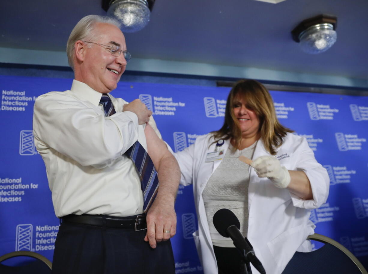 Health and Human Services Secretary Tom Price, left, is given a Band-Aid after a flu vaccination from Sharon Walsh-Bonadies, RN., right, during a Thursday news conference recommending everyone age 6 months and older be vaccinated against influenza each year.