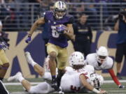 Washington’s Dante Pettis (8) leaves several Fresno State defenders in his wake on his punt return for a touchdown in the first half of an NCAA college football game Saturday, Sept. 16, 2017, in Seattle. Pettis tied the NCAA career record for punt return touchdowns on the 77-yard return, the eighth of his career.