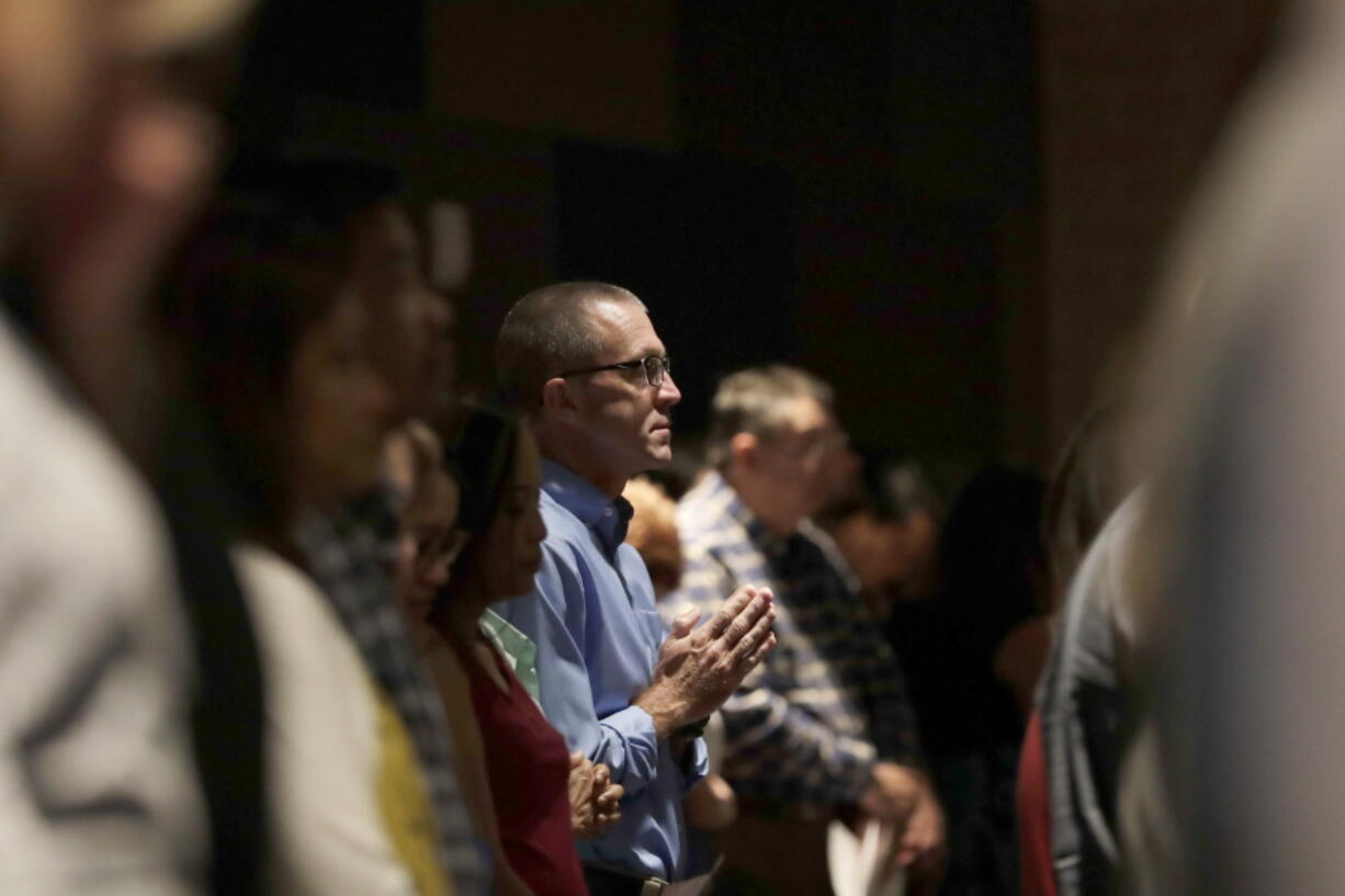 A man prays as he attends services for parishioners from flood-damaged St Ignatius Loyola Catholic Community Church in the auditorium of Klein High School Sunday, Sept. 3, 2017, in Klein, Texas. As clean up and repairs continue at the church just outside of Houston, parishioners turned this high school auditorium into their sanctuary on a Sunday that was declared National Day of Prayer for Harvey victims by President Donald Trump.