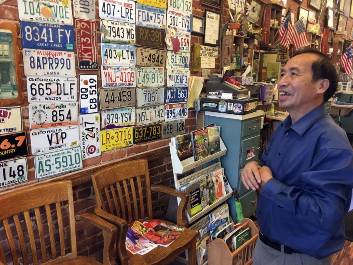 Anthony Pham, talks in his Monroe, Ga., barber shop. He became a U.S. citizen in 1987, five years after he immigrated from Vietnam.