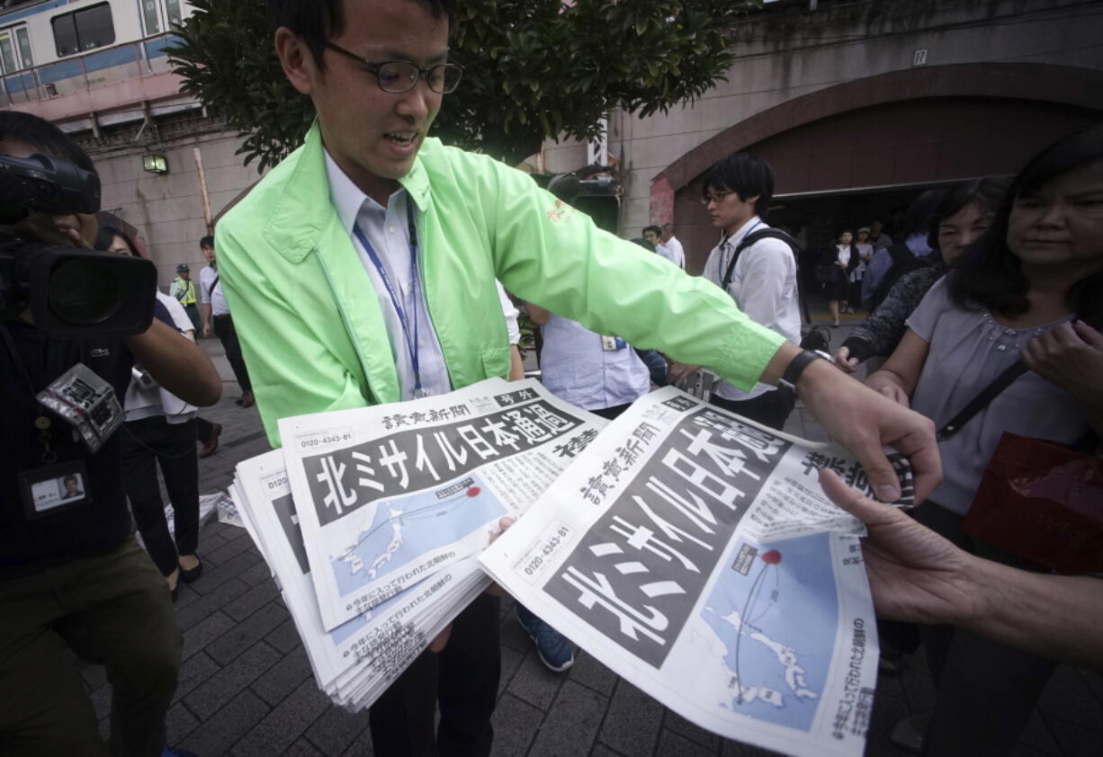 A man distributes an extra edition of a newspaper reporting about North Korea’s missile launch, at Shimbashi Station in Tokyo, Friday, Sept. 15, 2017. South Korea’s military said North Korea fired an unidentified missile Friday from its capital Pyongyang that flew over Japan before landing in the northern Pacific Ocean.