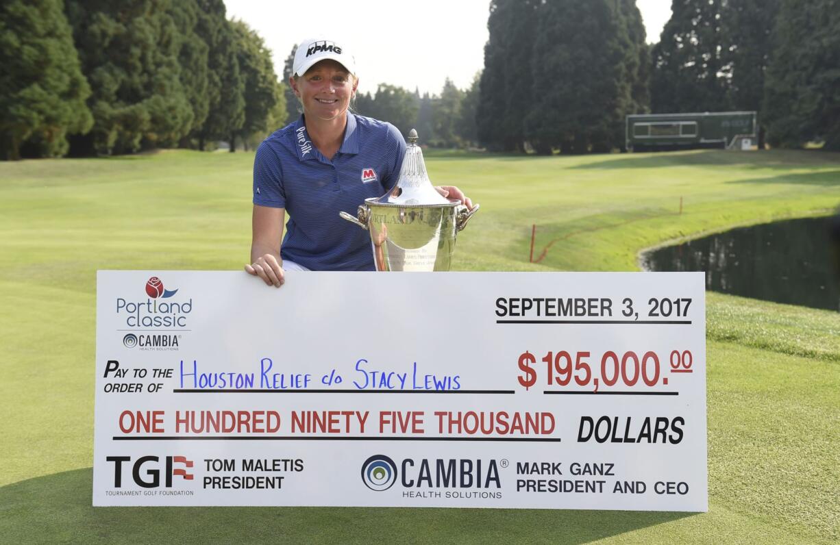 Stacy Lewis poses with the trophy and a check after winning the the Cambia Portland Classic golf tournament in Portland, Ore. on Sunday, Sept. 3, 2017. Lewis is donating her winnings to the Houston Relief to help the victims of Hurricane Harvey.