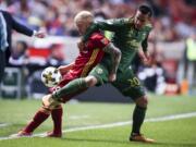 Real Salt Lake midfielder Luke Mulholland (19)fights for the ball with Portland Timbers midfielder David Guzman (20) during an MLS soccer match in Sandy, Utah, Saturday, Sept. 16, 2017.