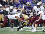 Washington running back Lavon Coleman (22) avoids a diving tackle attempt from Montana safety Justin Strong, lower left, as he rushes in the first half of an NCAA college football game, Saturday, Sept. 9, 2017, in Seattle. (AP Photo/Ted S.