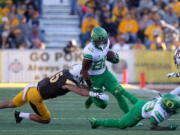 Oregon wide receiver Johnny Johnson III trips over runs past an attempted tackle from Wyoming linebacker Adam Pilapil (45) while Oregon wide receiver Darrian McNeal (89) blocks Wyoming cornerback Rico Gafford (5) during the first half of an NCAA college football game in Laramie, Wyo., Saturday, Sept.16, 2017.