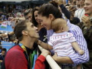 United States’ swimmer Michael Phelps celebrates winning his gold medal in the men’s 200-meter butterfly with his fiance Nicole Johnson and baby Boomer during the swimming competitions at the 2016 Summer Olympics in Rio de Janeiro, Brazil. Phelps says he has “no desire” to return to competitive swimming, but he’s eager to stay involved with the sport and cheer on those who follow in his enormous wake.