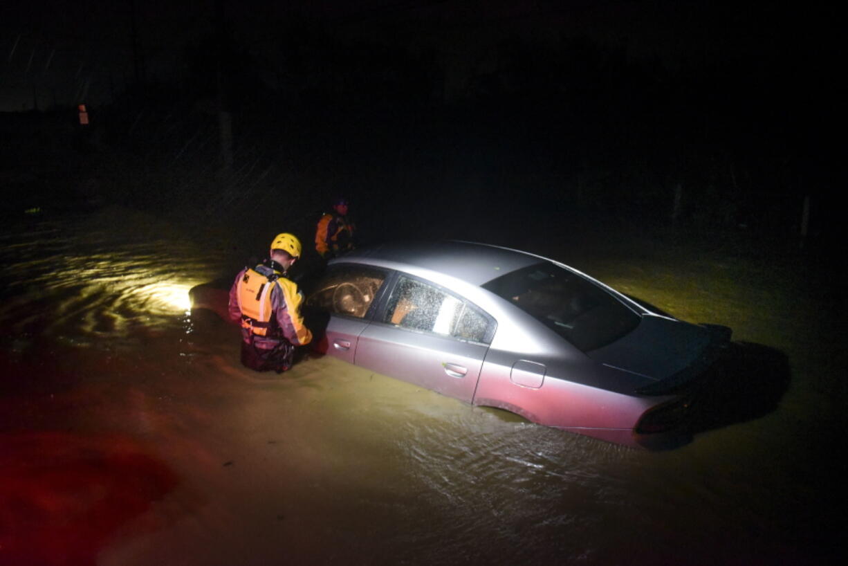 Rescue staff from the Municipal Emergency Management Agency investigate an empty flooded car during the passage of Hurricane Irma through the northeastern part of the island in Fajardo, Puerto Rico, Wednesday, Sept. 6, 2017. Hurricane Irma lashed Puerto Rico with heavy rain and powerful winds, leaving nearly 900,000 people without power as authorities struggled to get aid to small Caribbean islands already devastated by the historic storm.