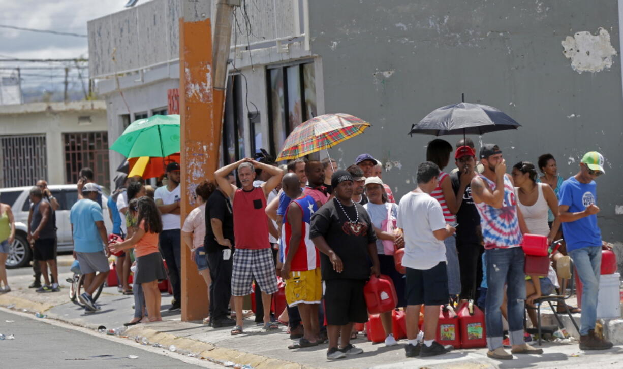 People line up with gas cans Mondayt to get fuel from a gas station in the aftermath of Hurricane Maria in San Juan, Puerto Rico. The U.S. ramped up its response Monday to the humanitarian crisis in Puerto Rico while the Trump administration sought to blunt criticism that its response to Hurricane Maria has fallen short of it efforts in Texas and Florida after the recent hurricanes there.