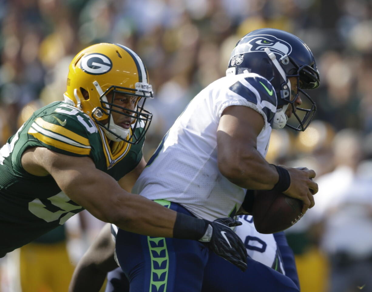 Green Bay’s Nick Perry sacks Seattle Seahawks’ Russell Wilson, who was given little time to throw throughout Sunday’s season-opening loss to the Packers.