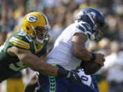 Green Bay’s Nick Perry sacks Seattle Seahawks’ Russell Wilson, who was given little time to throw throughout Sunday’s season-opening loss to the Packers.