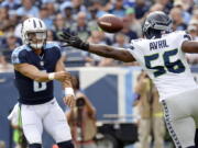 Tennessee Titans quarterback Marcus Mariota (8) passes past Seattle Seahawks defensive end Cliff Avril (56) in the first half of an NFL football game, Sunday, Sept. 24, 2017, in Nashville, Tenn.