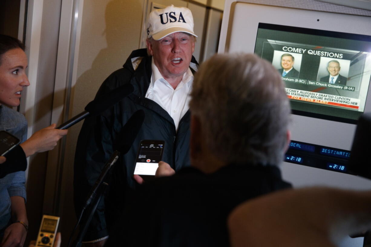 President Donald Trump talks with reporters aboard Air Force One, Thursday, Sept. 14, 2017, en route to Washington.