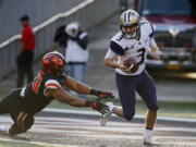 Washington quarterback Jake Browning (3) escapes the tackle attempt by Oregon State’s Titus Failauga in the first half of an NCAA college football game, in Corvallis, Ore., Saturday, Sept. 30, 2017. (AP Photo/Timothy J.