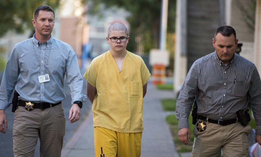 Spokane County Sheriff’s deputies escort suspect Caleb Sharpe to the Juvenile Detention Center on Wednesday in Spokane.