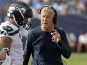 FILE - In this Sept. 24, 2017, file photo, Seattle Seahawks head coach Pete Carroll talks with quarterback Russell Wilson in the first half of an NFL football game against the Tennessee Titans in Nashville, Tenn.