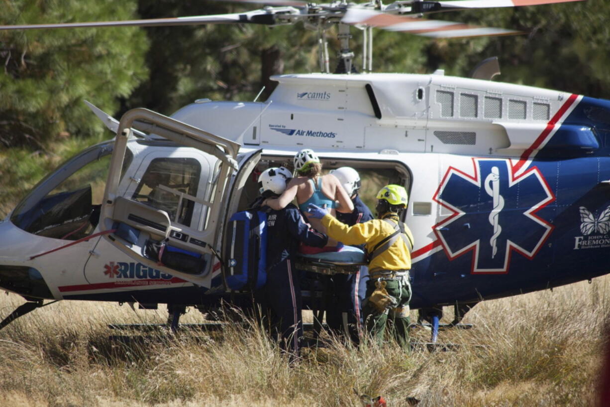 In this Wednesday, Sept. 27, 2017, photo provided by Dakota Snider, photographer and Yosemite resident, a woman is carried into a helicopter after being rescued off El Capitan following a major rock fall in Yosemite National Park, Calif. All areas in California’s Yosemite Valley are open Thursday, a day after the fatal rock fall.