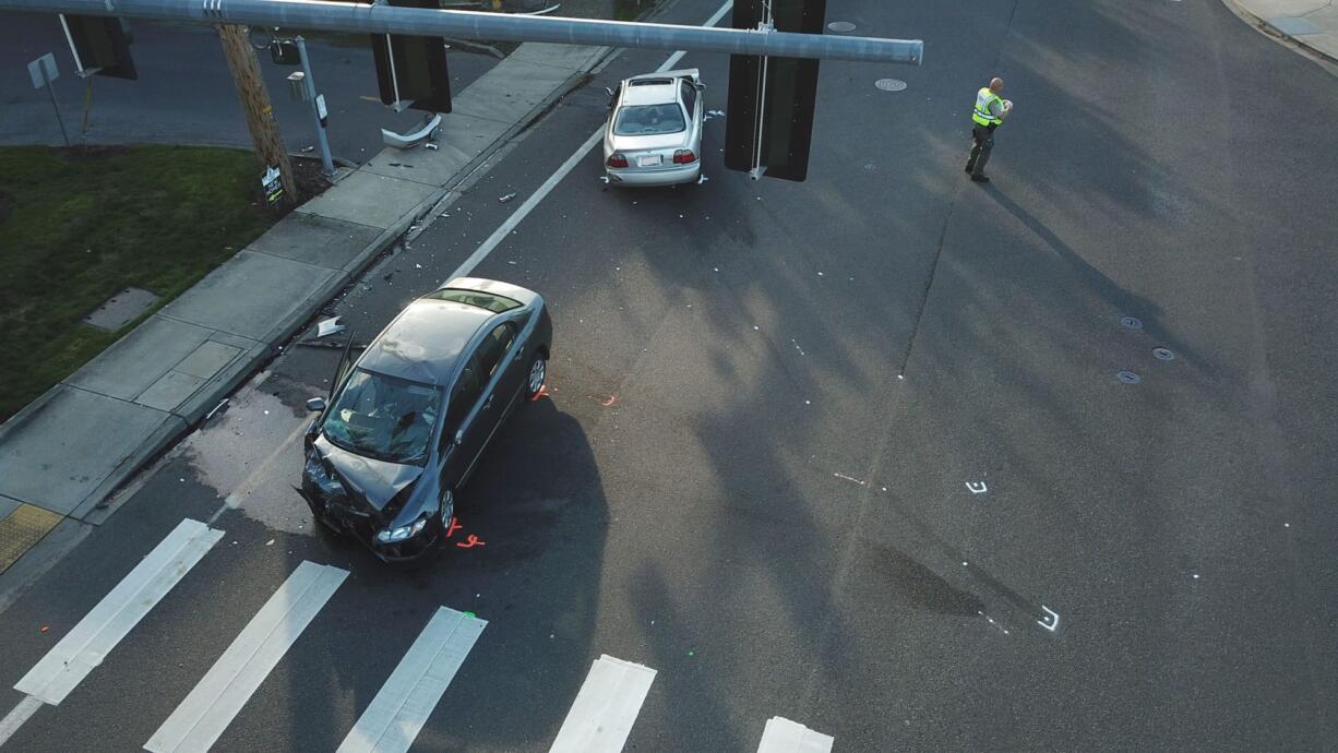 Deputies review the scene after a stolen car, which the sheriff's office said was fleeing police pursuit, hit another car at Northeast 124th Avenue and Northeast 99th Street Tuesday. One person was injured and the fleeing driver was arrested.