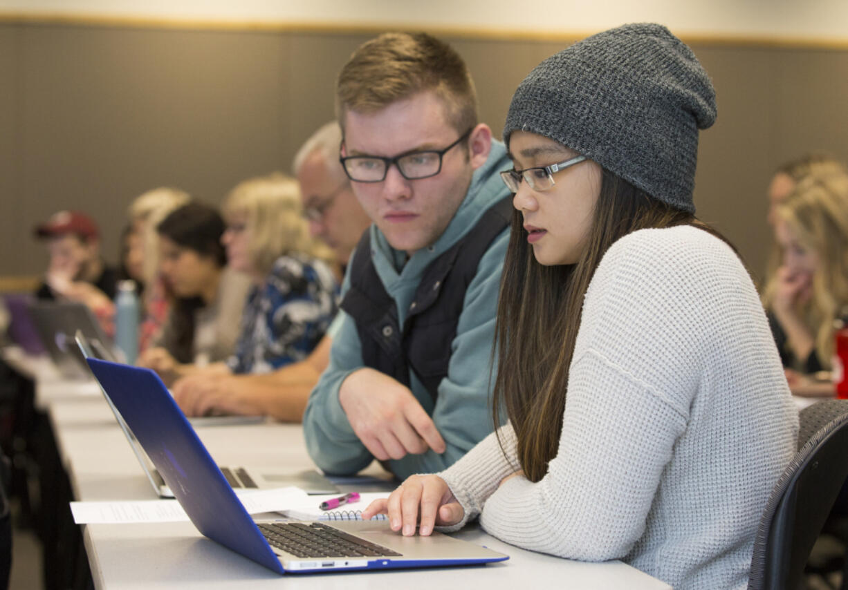 Junior Brayden Cooley, left, and senior Maciel Draculan work on a digital polarization initiative assignment at Washington State University Vancouver.