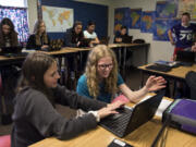 Frontier Middle School seventh-graders Sara Finnie, left, and Brynn Lantagne, right, use their Chromebooks to work on geography learning games during Kim Souchex’s humanities class.