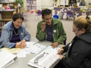 Clarita Manrique, from left, originally from Colombia, Ali Alquraisha, a volunteer originally from Kuwait, and Fidelina Ayala, originally from Mexico, work through exercises in an English class offered at Hathaway Elementary School through a partnership between the Washougal School District and Clark College.