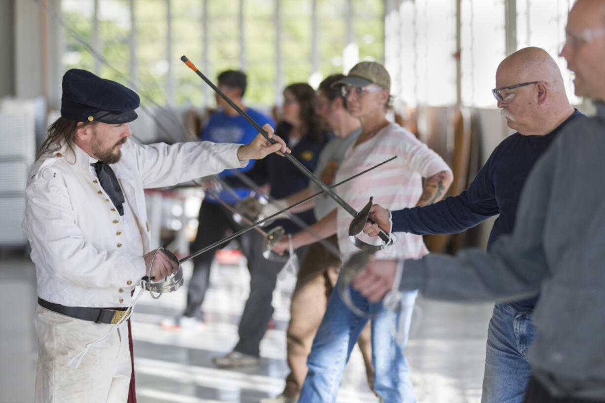 Instructor Jeff Richardson from Academia Duellatoria, left, checks Herb Maxey’s posture during a saber training course at Pearson Air Museum on Sunday.