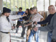 Instructor Jeff Richardson from Academia Duellatoria, left, checks Herb Maxey’s posture during a saber training course at Pearson Air Museum on Sunday.