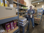 Volunteer John Kaloudis sorts donated food while helping to clients at Friends in Service to Humanity Westside Food Pantry of Vancouver, otherwise known as FISH.