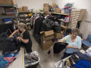 Volunteers Vickie Neal, left, and Diane Kessell sort through donated clothes at Friends in Service to Humanity Westside Food Pantry of Vancouver, otherwise known as FISH. Kessell said they are always in need of clothing donations, especially men’s clothes.