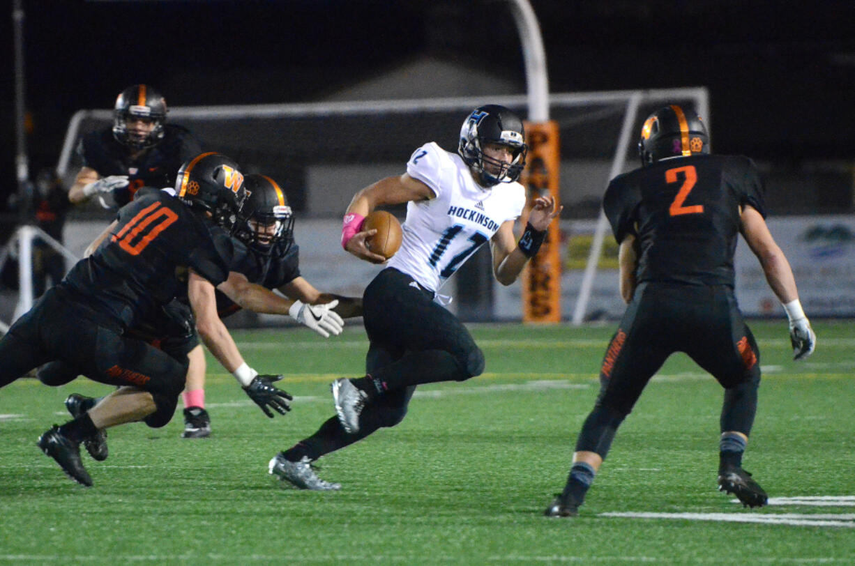 Hockinson quarterback Canon Raconelli evades Washougal defenders at Washougal High School on Friday, October 6, 2017.