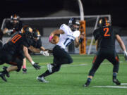 Hockinson quarterback Canon Raconelli evades Washougal defenders at Washougal High School on Friday, October 6, 2017.